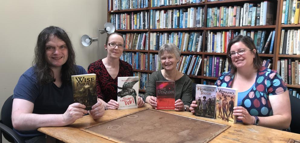 达尼丁投机小说作家小组的创始成员(左起)Daniel Stride,Kura Carpenter,Carolyn McCurdie和Debbie Howell聚集在雅典娜图书馆举行定期会议。照片:Mark McCabe Founding members of the Dunedin Speculative Fiction Writer’s Group, (from left) Daniel Stride, Kura Carpenter, Carolyn McCurdie, and Debbie Howell gather for one of their regular meetings at the Athenaeum Library. Photo: Mark McCabe