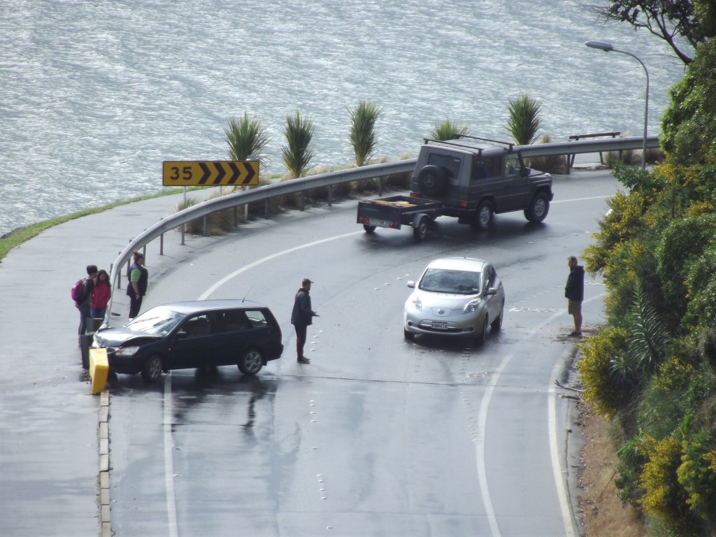 Bystanders assist after a single vehicle accident at Burns Point yesterday afternoon. Photo David...