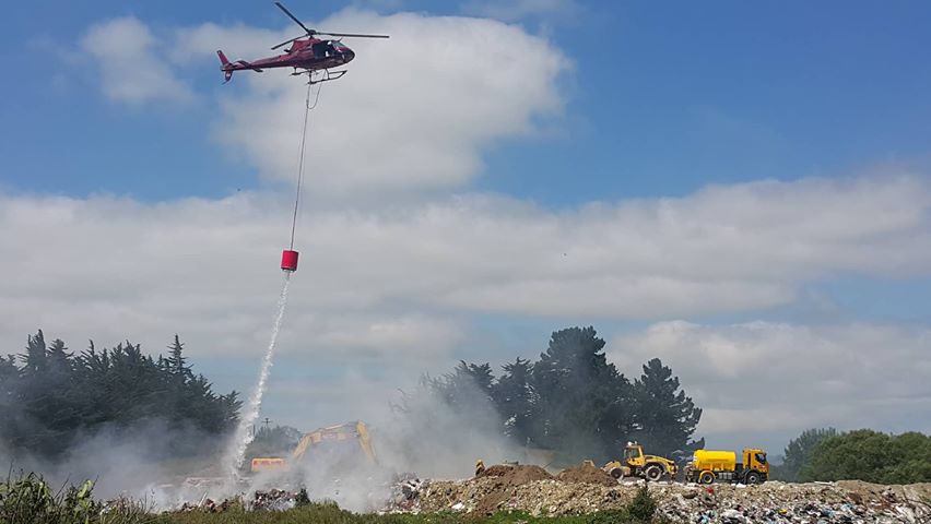 A helicopter with a monsoon bucket helps fight the blaze. Photo: George Block