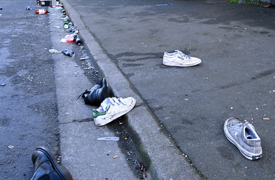 Shoes lie in the street outside the property on Sunday morning. Photo: Linda Robertson