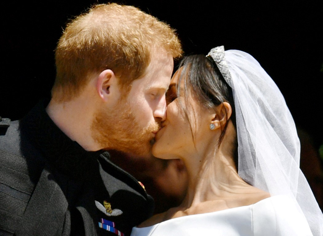 Prince Harry and Meghan Markle kiss on the steps of St George's Chapel in Windsor Castle after...