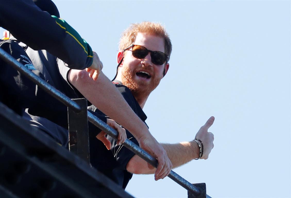 Prince Harry gives a thumbs-up as he climbs the Sydney Harbour Bridge. Photo: Reuters