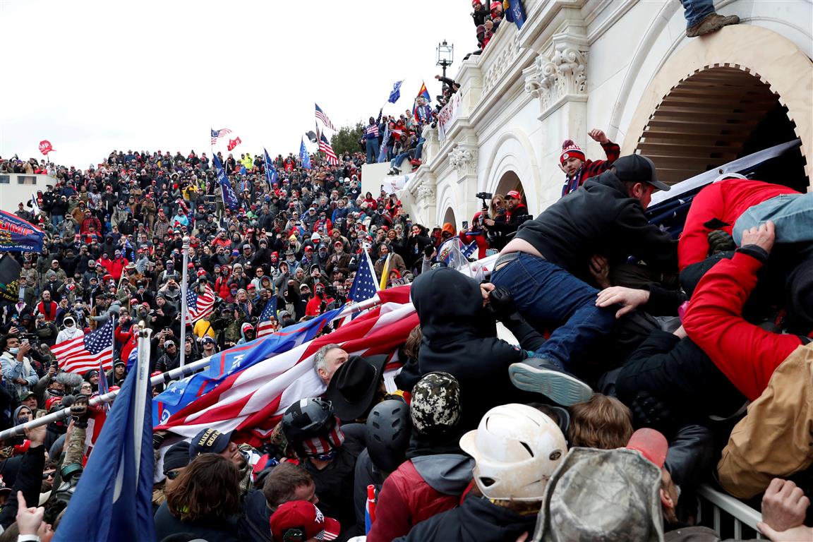 Protesters storm into the US Capitol during clashes with police in Washington yesterday. Photo:...