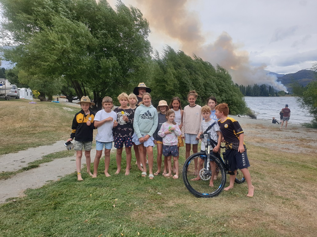 Some Wanaka children at Glendhu Bay camp ground as smoke from the fire rises behind them. Photo...