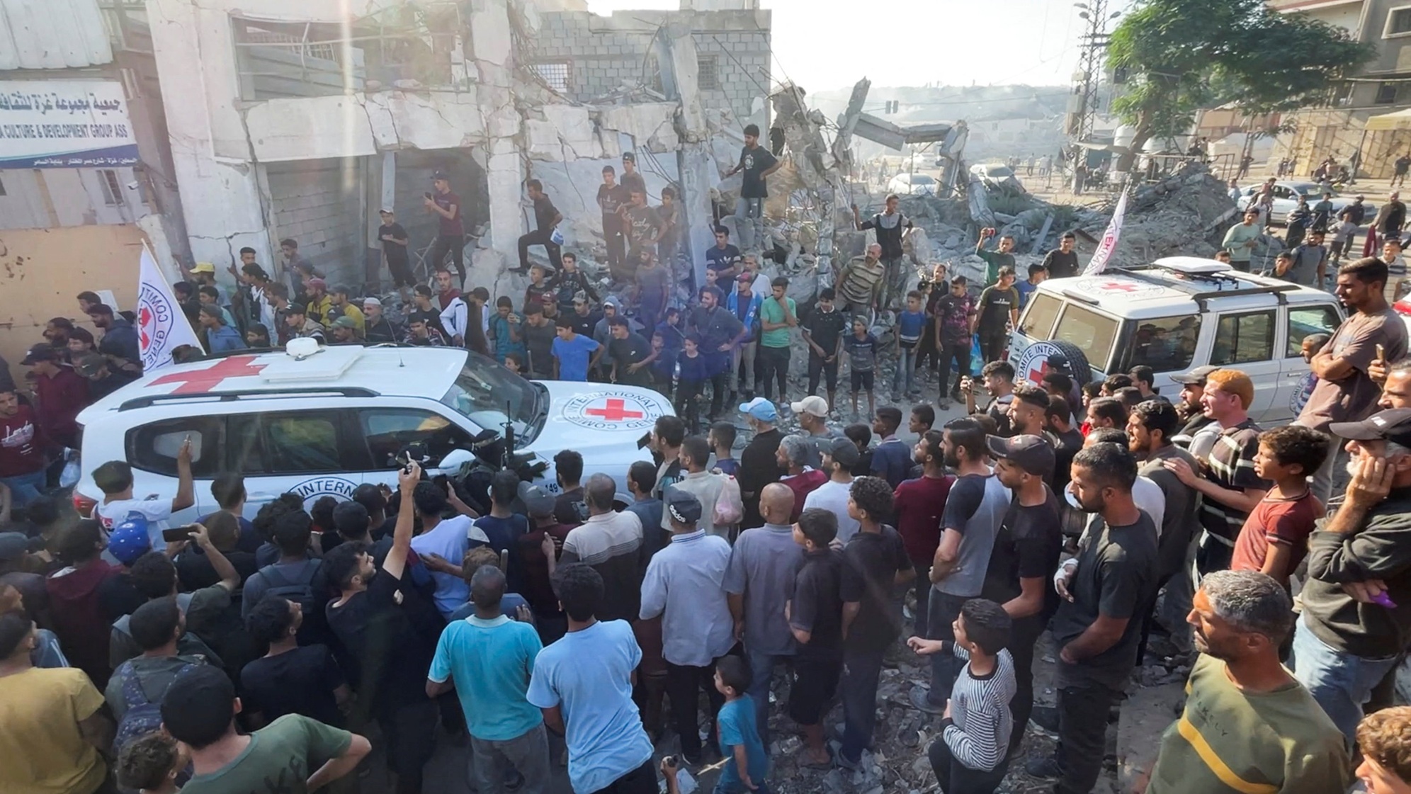 Red Cross vehicles transport hostages in Gaza City following their handover as part of a...