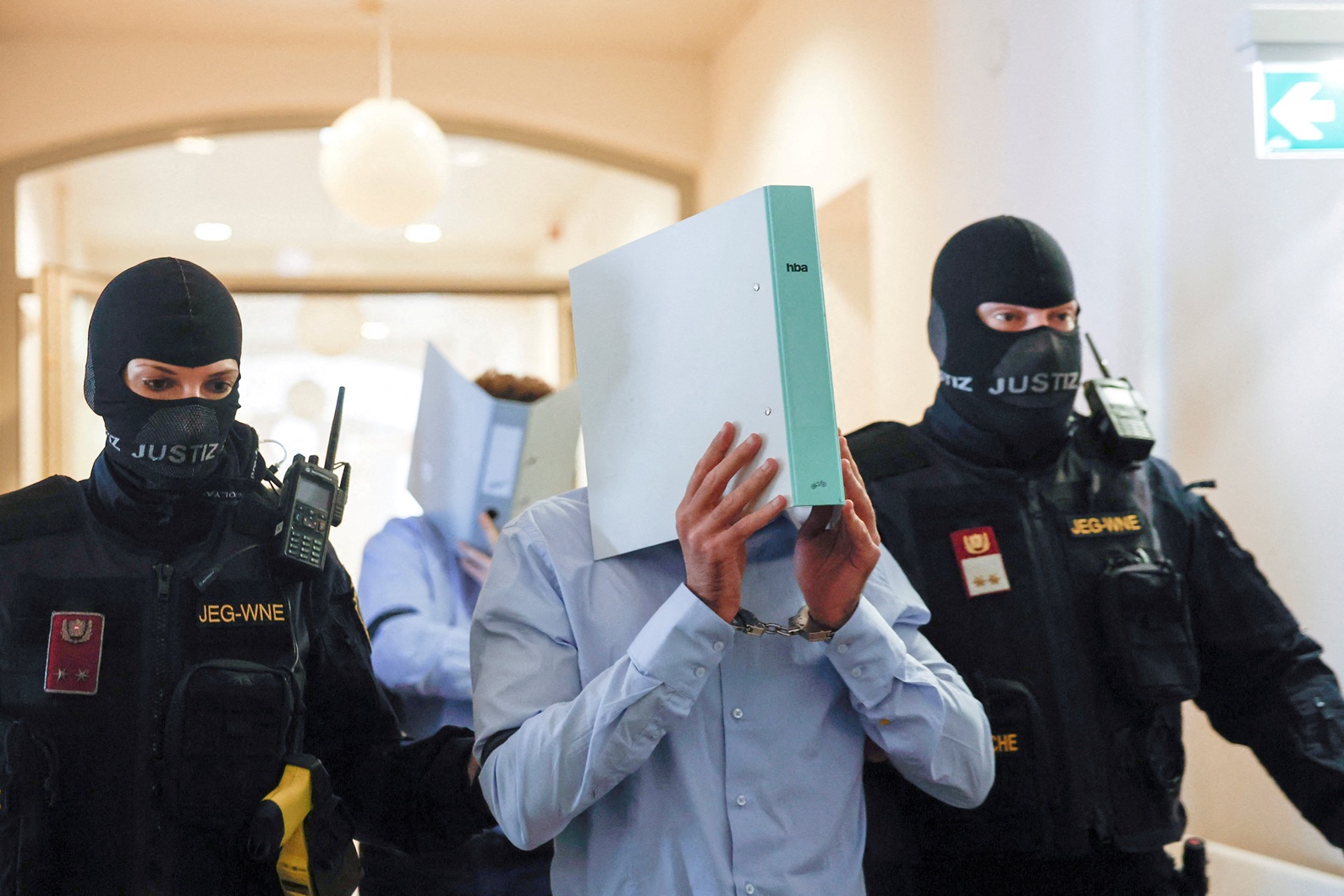 Suspect Beran A is escorted by security personnel in a courtroom for his trial in Wiener Neustadt...