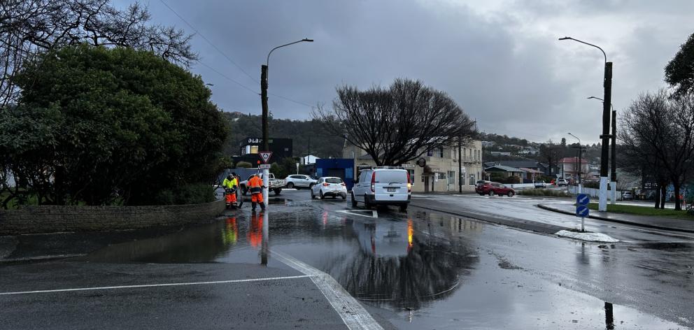 Workers clear drains at Forbury Corner this morning. Photo: Gregor Richardson