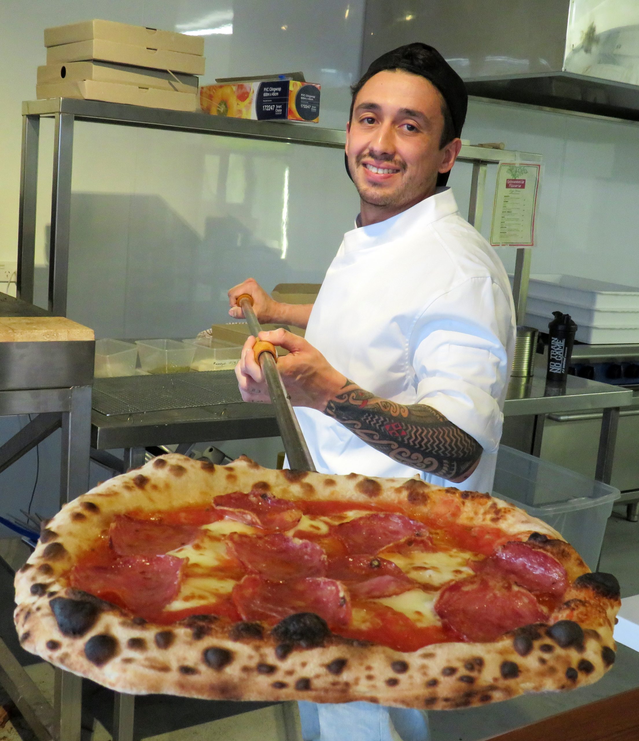 Giovanni's chef Thiago Pires with a pizza out of the oven. Photo: Supplied