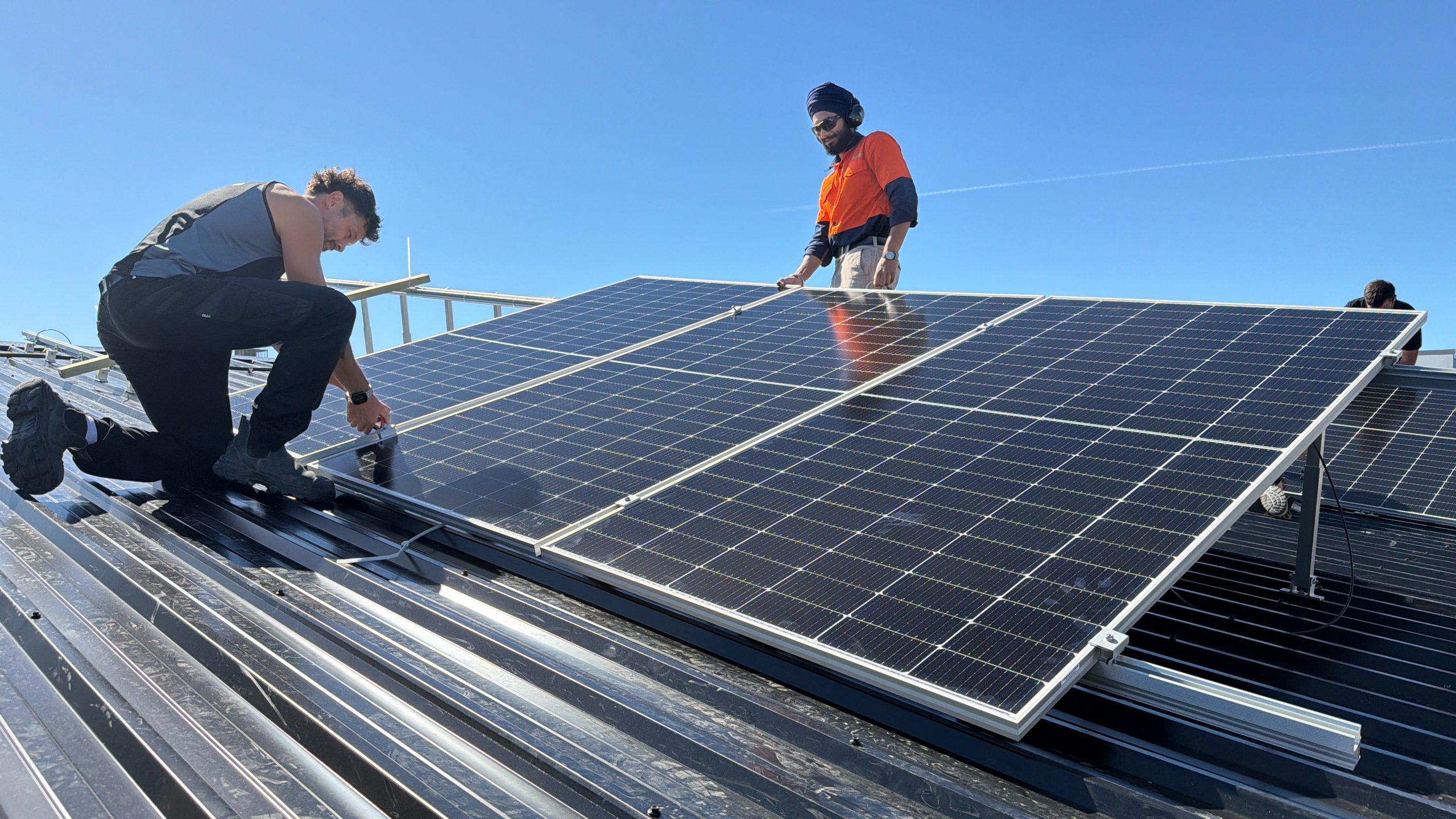 Installing solar panels on the roof of Community House Mid Canterbury are ElectraServe staff...