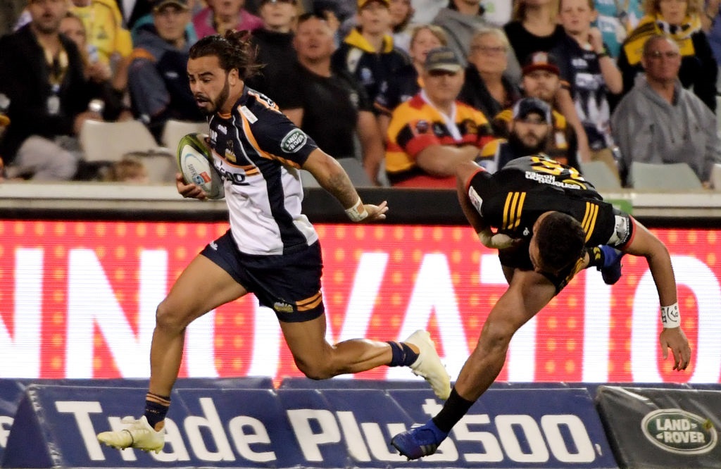 Brumbies player Andy Muirhead dodges Shaun Stevenson of the Chiefs at Canberra's GIO Stadium....