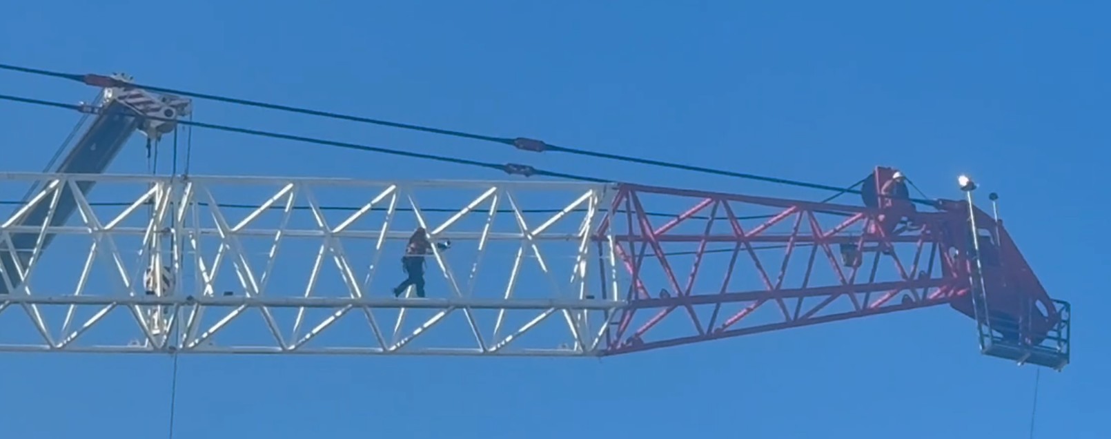 Watch your step .... a crane operator walks across a boom high above Dunedin.