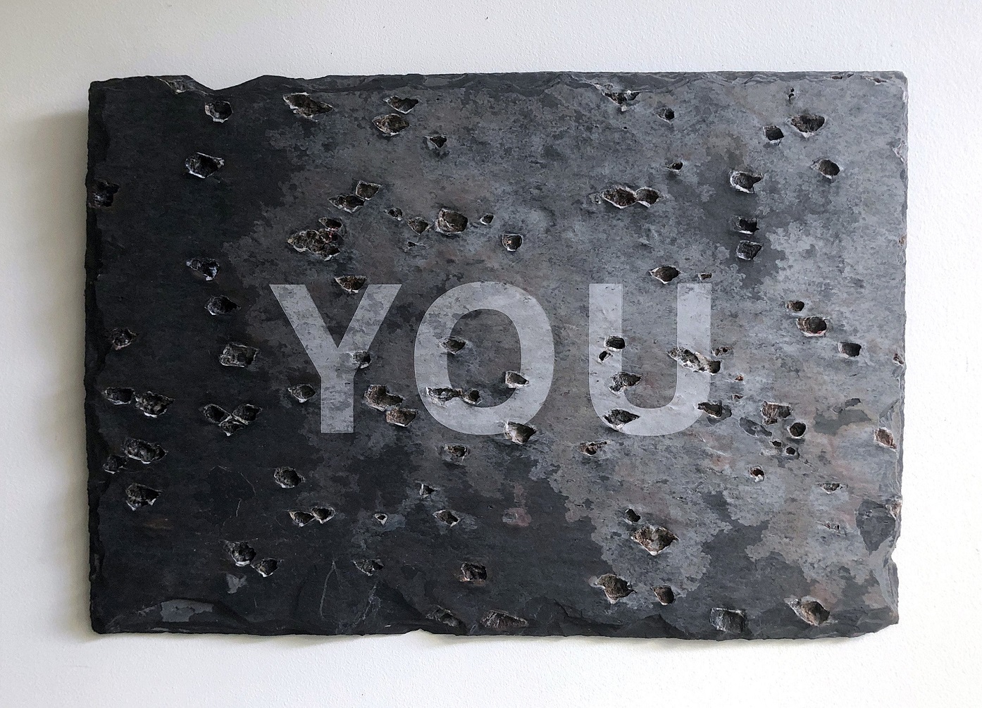 One of the Chinese slate roof tiles into which Deborah Rundle etched one word each, to read: "On...