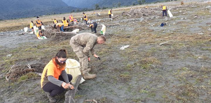 People clean up rubbish spilled from the Fox Glacier landfill. Photo: Photo: supplied