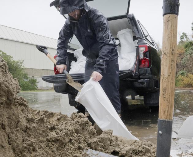South Dunedin resident Daniel Suddaby fills sand bags at the Dunedin Ice Stadium carpark...