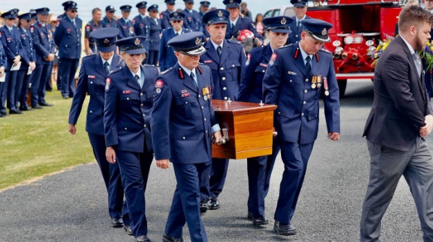 Firefighters carry the coffin containing David van Zwanenberg during the funeral in Muriwai....