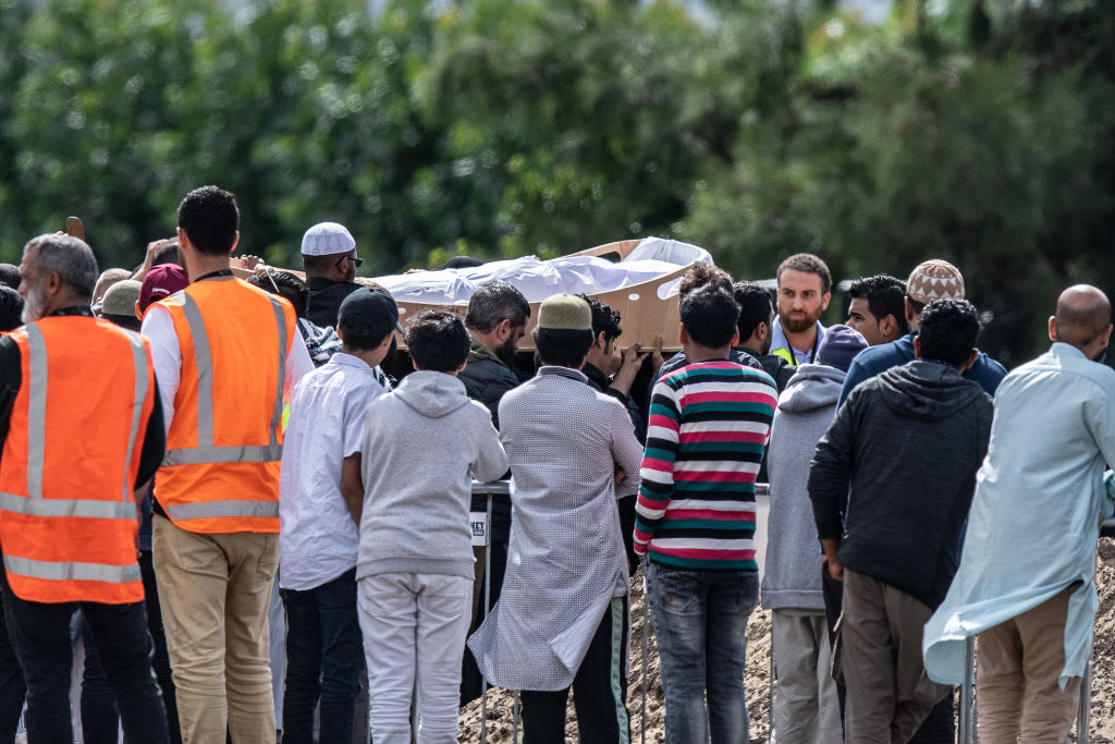 A coffin containing one of the bodies is carried for burial at Memorial Park Cemetery in...