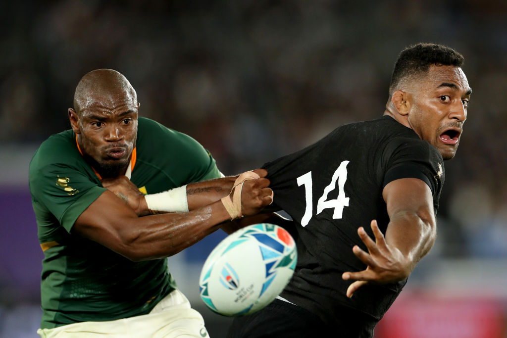 All Black winger Sevu Reece offloads the ball in front of his Springbok counterpart, Makazole...