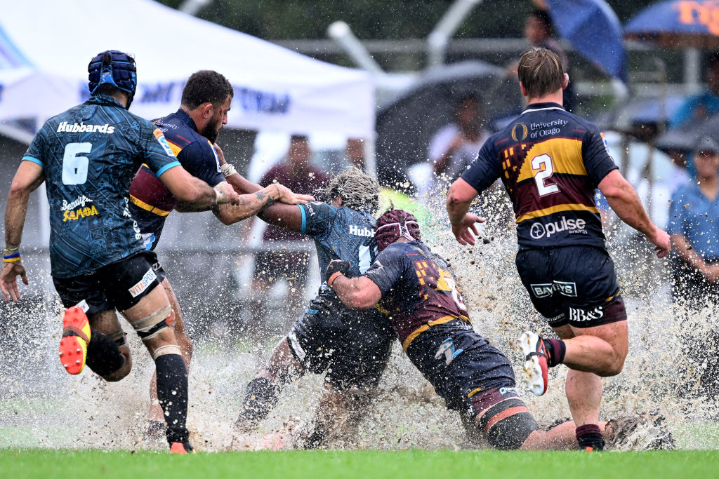 Highlanders skipper Billy Harmon tackles Moana Pasifika's Fine Inisi on a wet day in Nuku’alofa....