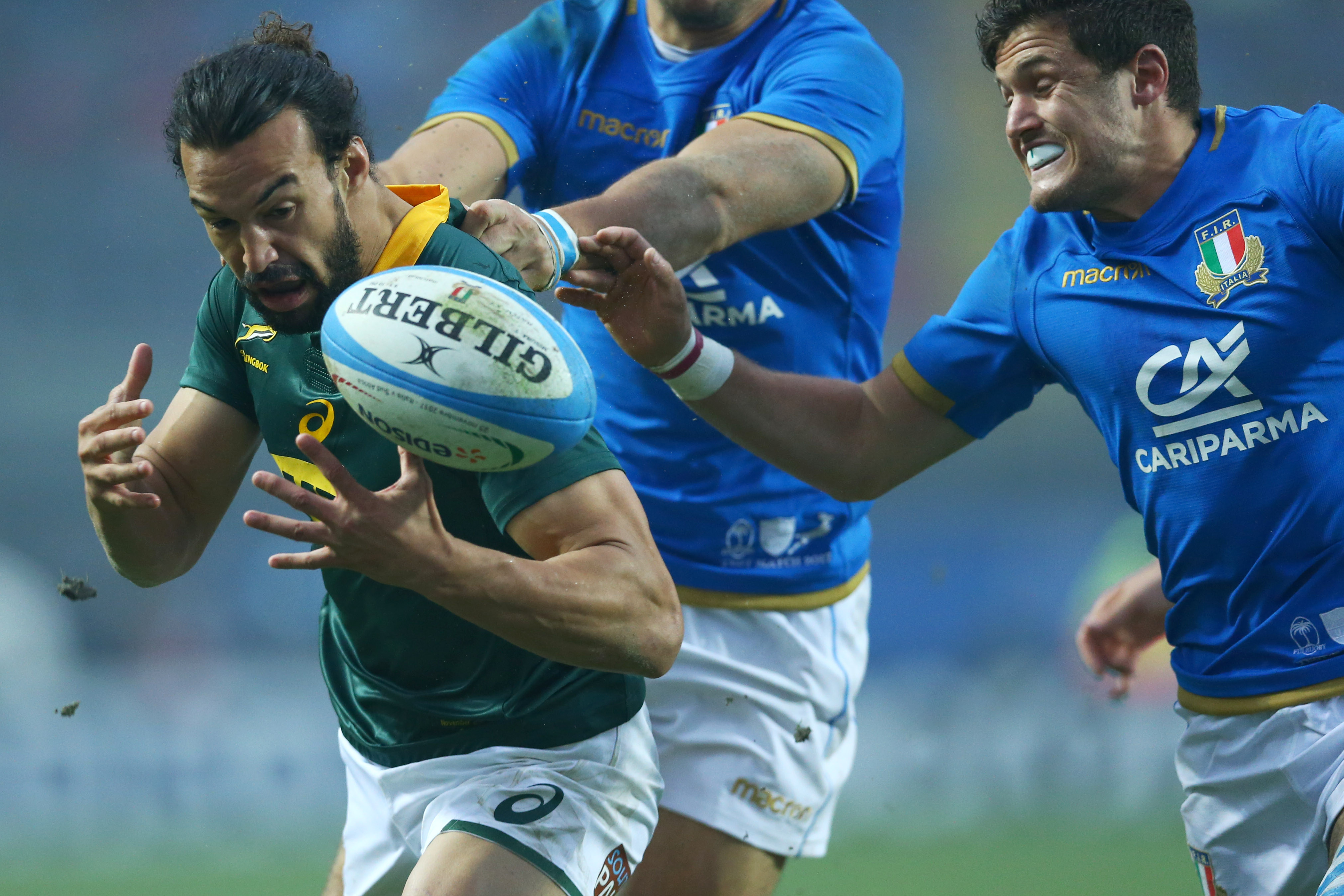 Springbok Dillyn Leyds tries to evade a tackle from Italy's Marcello Violi (right). Photo: Getty Images 