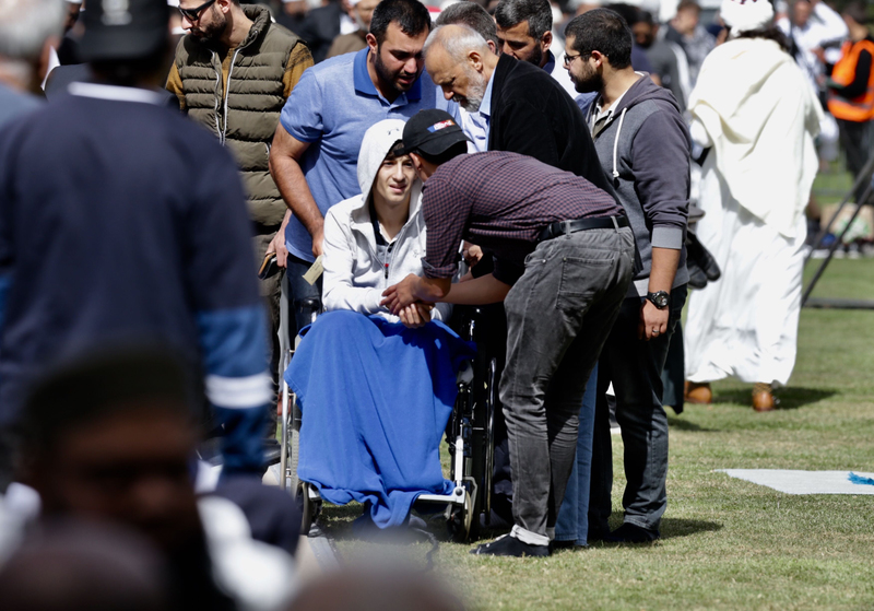 Zaid Mustafa (14) greets worshippers at prayers in Hagley Park. Photo: NZ Herald  