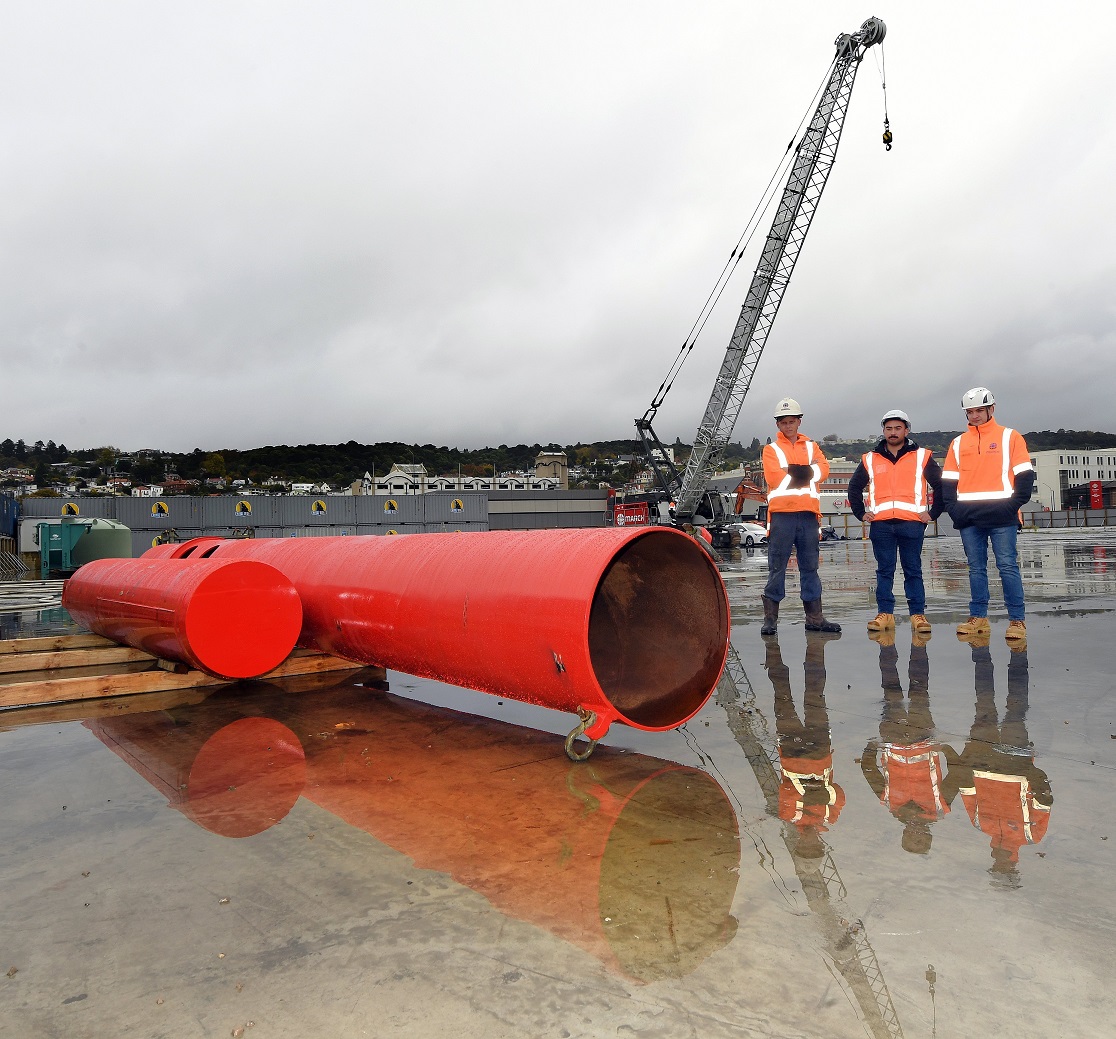 Standing beside the 14-tonne pile-driving hammer are (from left) site supervisor Simon Ball,...