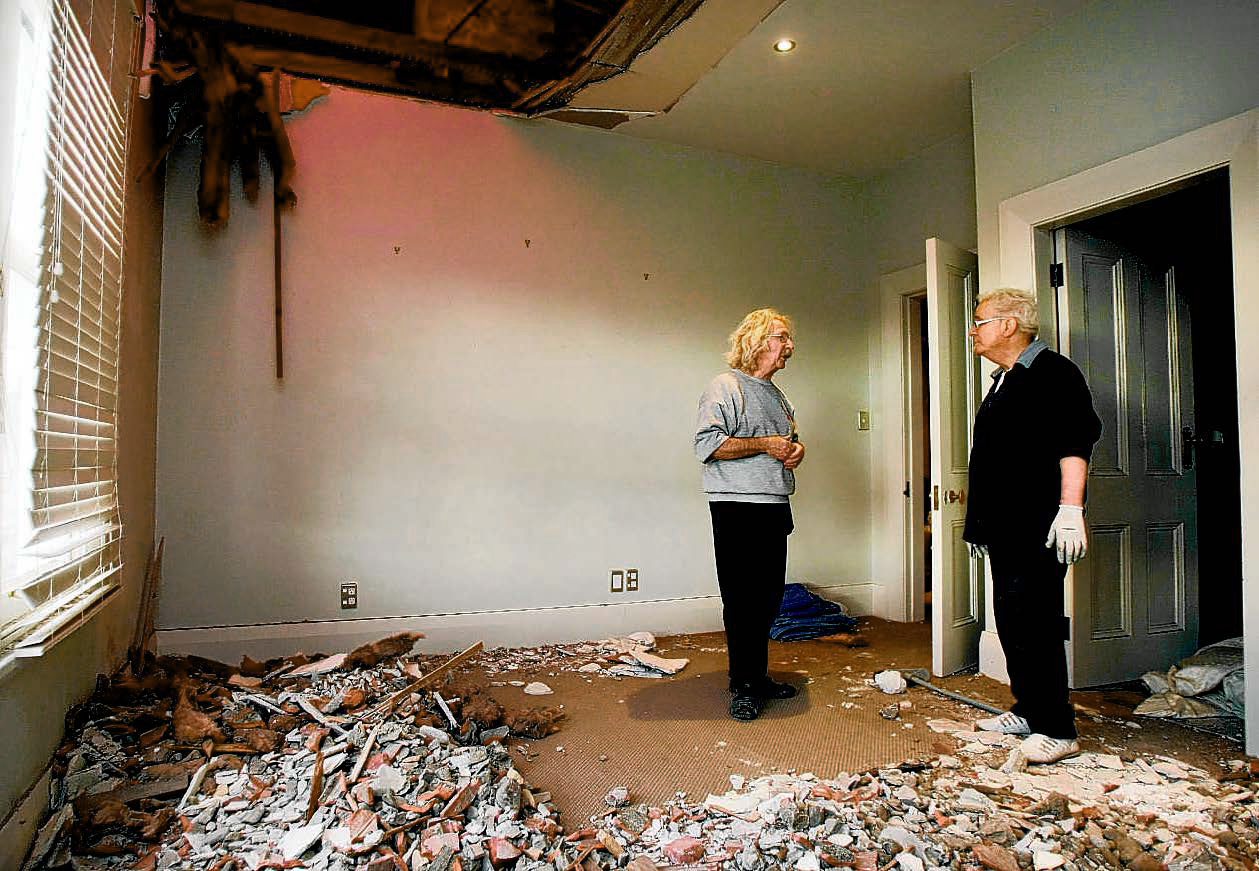 Owen Fraser and Kenneth McCaul study the mess in this Kaiapoi home.