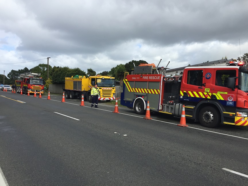 Two fire appliances and a water tanker (yellow) on SH1 near the fire scene. Photo: Giordano Stolley