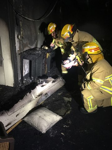 Firefighters inspect damage in the basement. Photo: Supplied/Mark Leonard