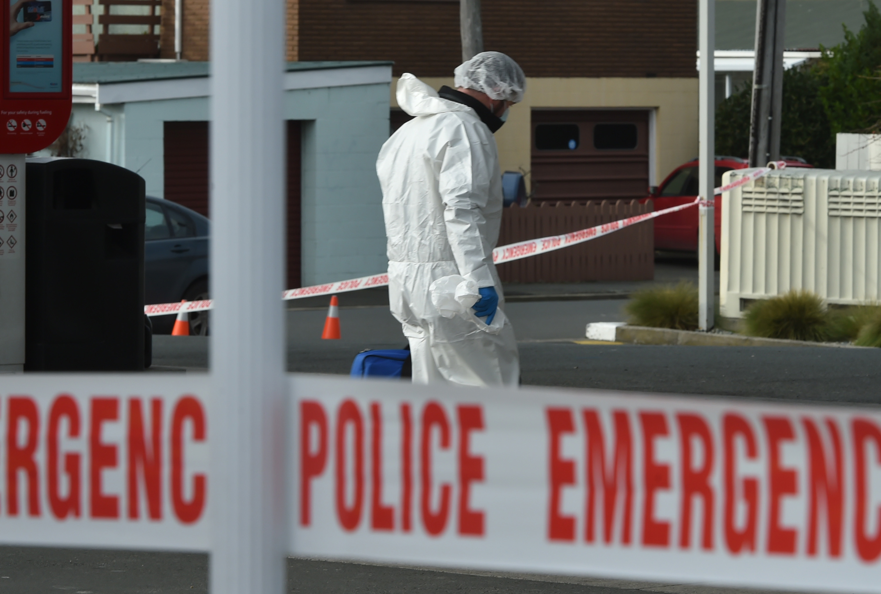 Police begin searching the Mobil forecourt on Sunday morning. Photo: Gregor Richardson