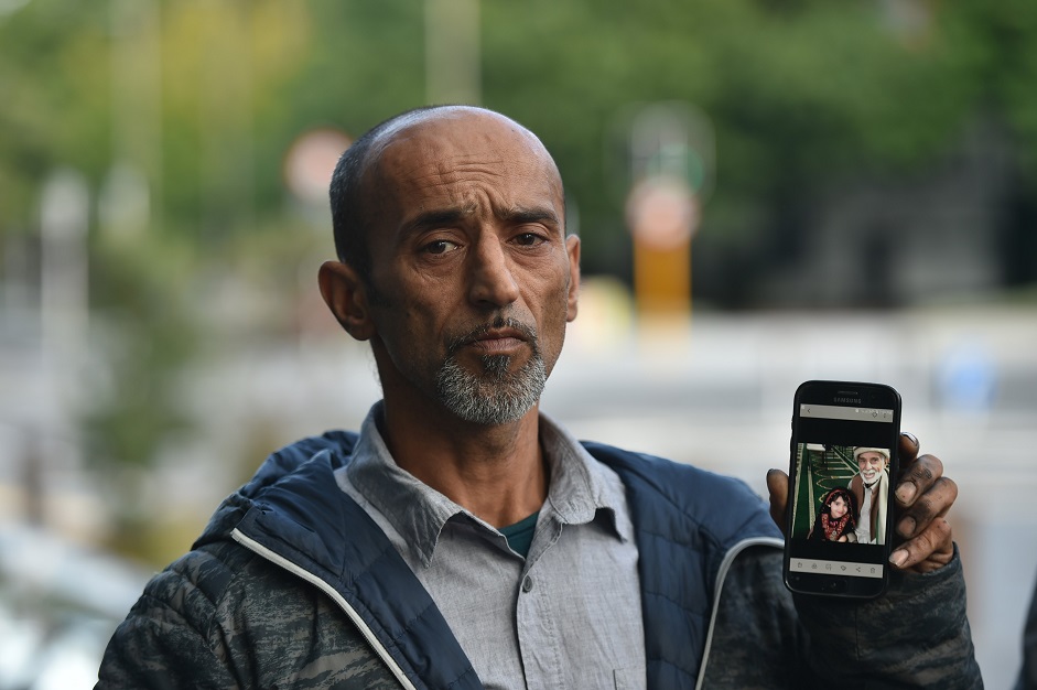 Omar Nabi holds his cellphone with a photo of his father, Haji Daoud Nabi, outside the District...
