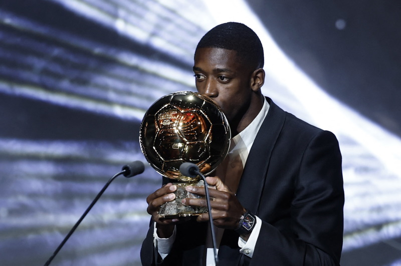 Ousmane Dembele kisses the Ballon d'Or trophy after being named the winner at the awards ceremony...