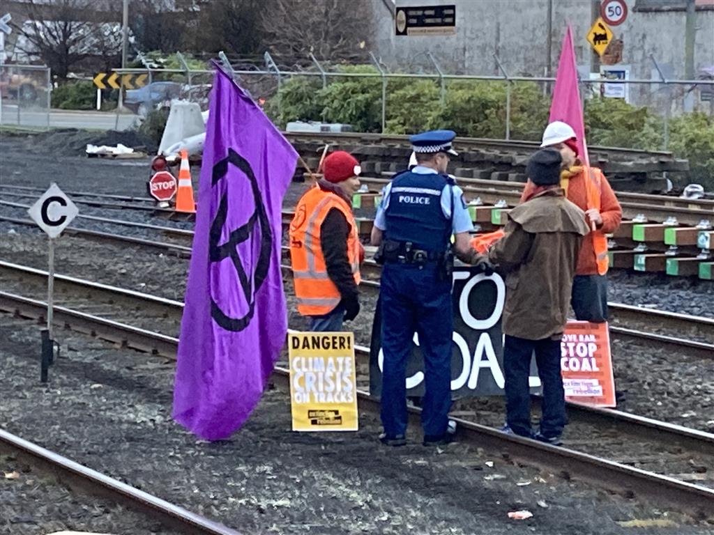 A police officer talks with activists protesting at Dunedin Railway Station this morning. Photo:...