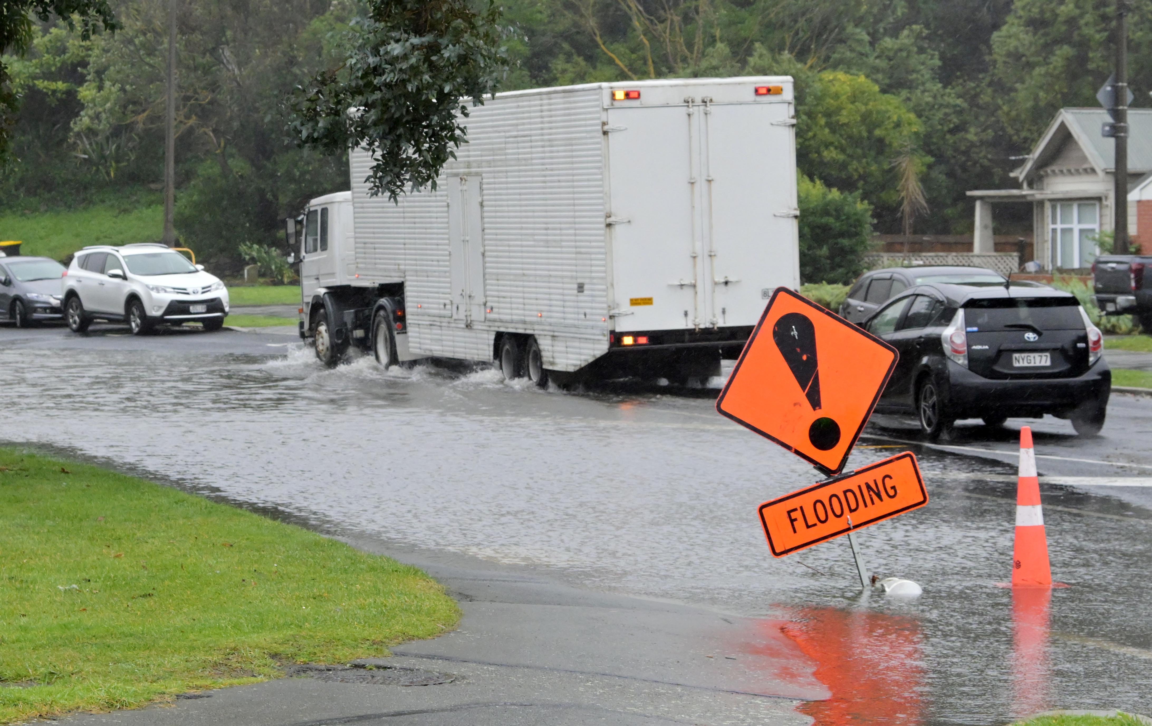 A truck and car negotiate flooding across all lanes of Portobello Rd near Bays Junction on...