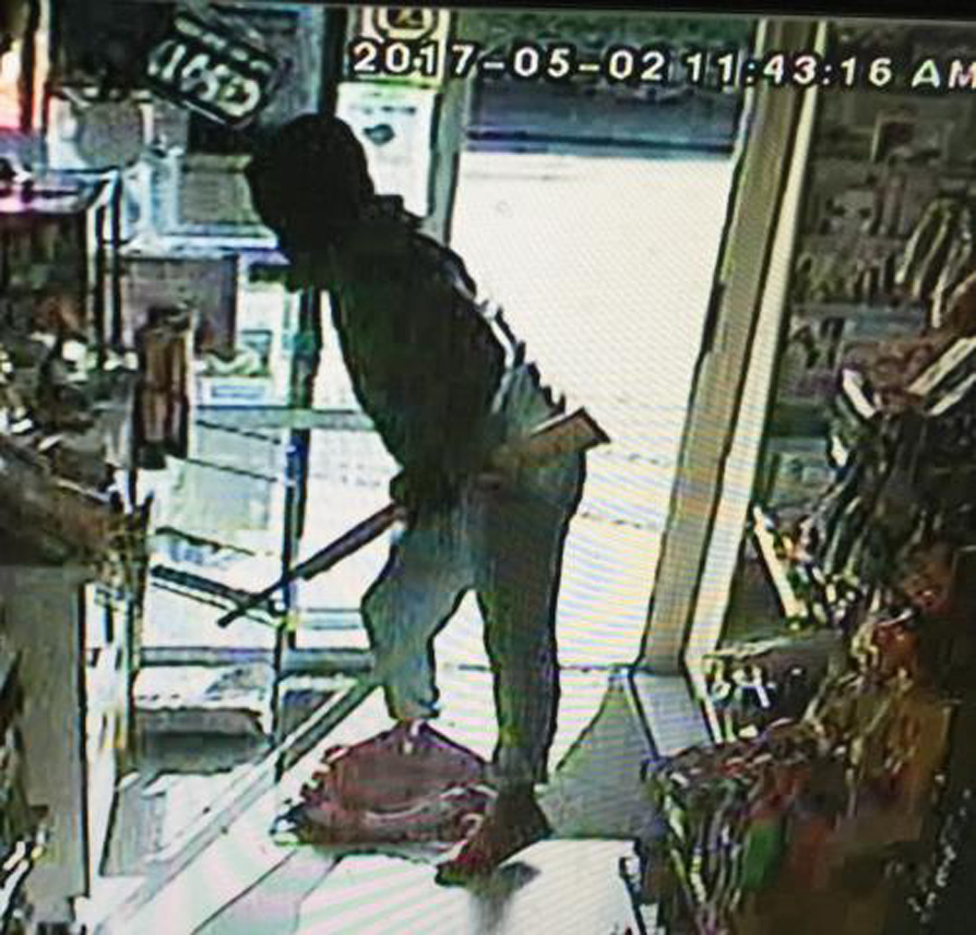 A masked man, armed with a rifle, is captured by a security camera entering the On the Spot...