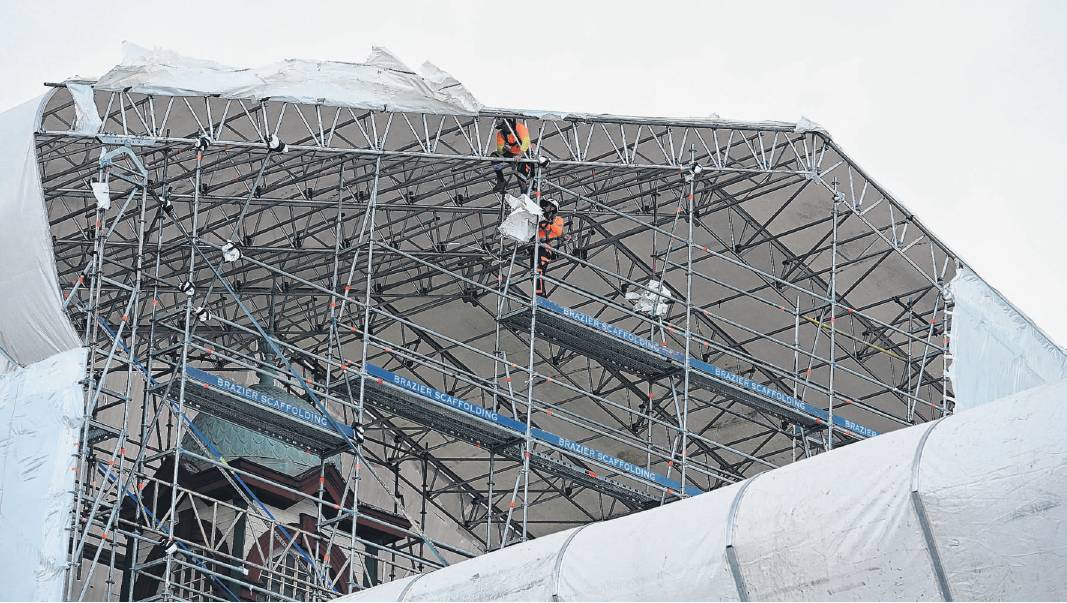Damage to the Dunedin Railway Station is averted as contractors work to secure printed scrim that...