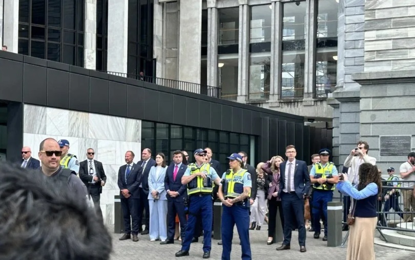 Flanked by police and Diplomatic Protection Services staff, David Seymour faces Treaty Principles...