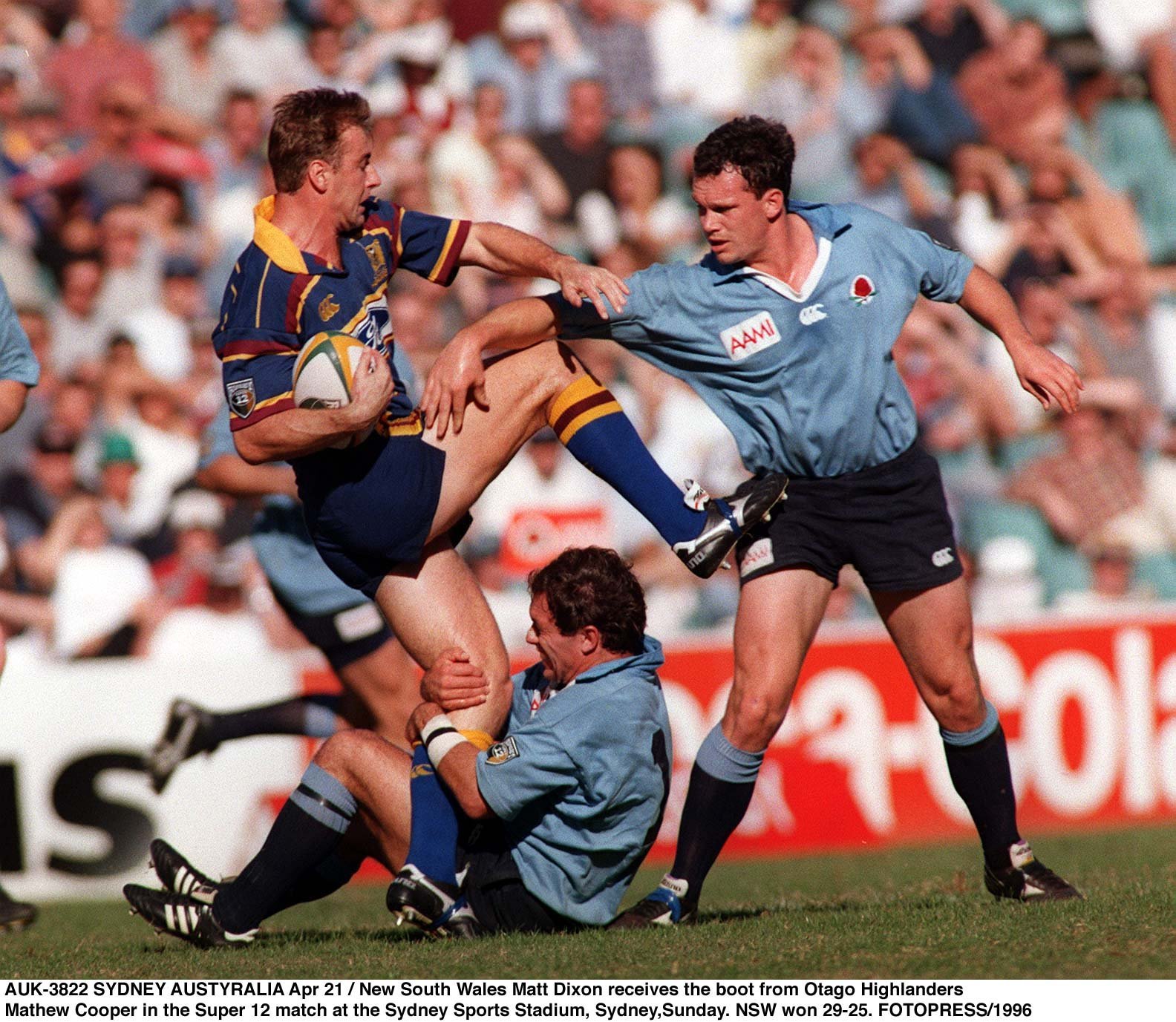 Highlanders centre fullback Matthew Cooper attempts to ward off the attention of Waratahs 
...