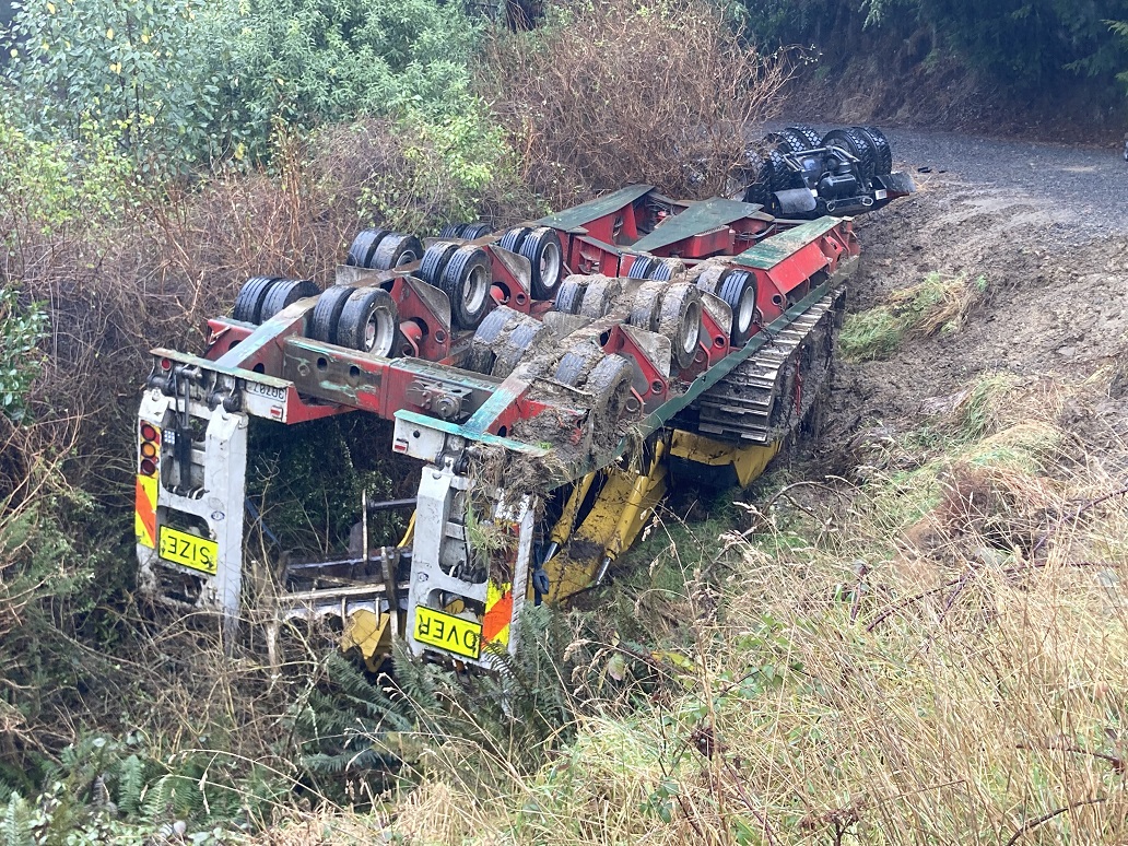 A truck carrying an excavator rolled off a road near the city's Northern Motorway early this...