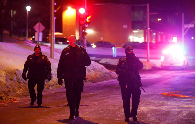 Police officers patrol the perimeter near a mosque after a shooting in Quebec City, Canada. Photo...