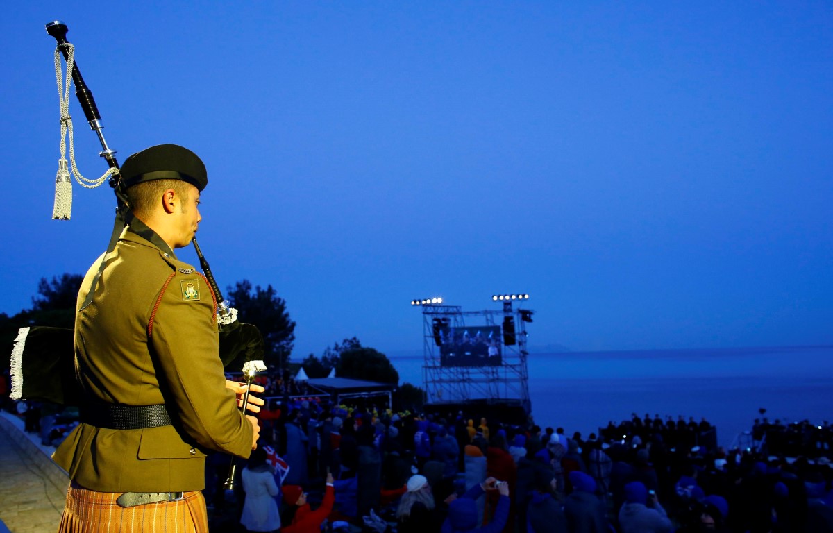 A bagpiper performs during a dawn ceremony at Anzac Cove on the Gallipoli peninsula in Turkey,...