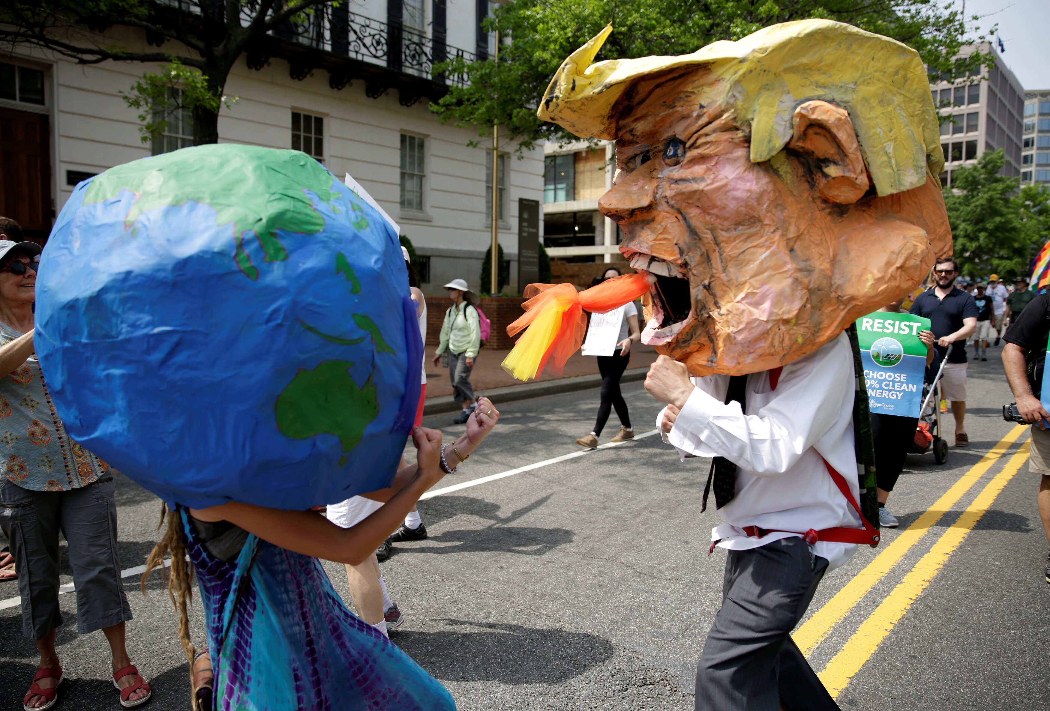 Protesters dressed as Earth and US President Donald Trump pretend to fight during the march....