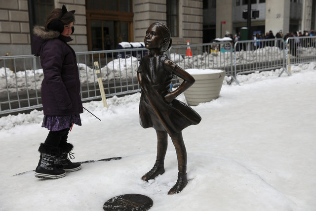 A girl looks at the 'Fearless Girl' statue which stands in front of Wall Street's Charging Bull statue in New York. Photo: Reuters