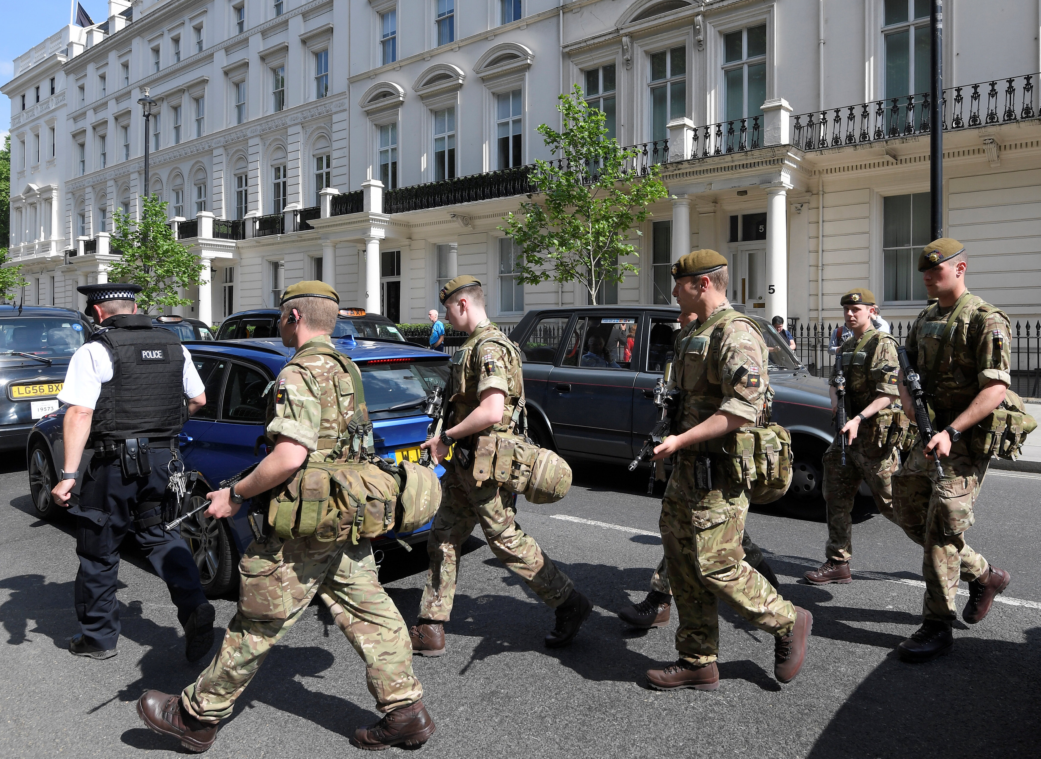 Soldiers cross a road with a police officer in central London. Up to 3800 soldiers could be...