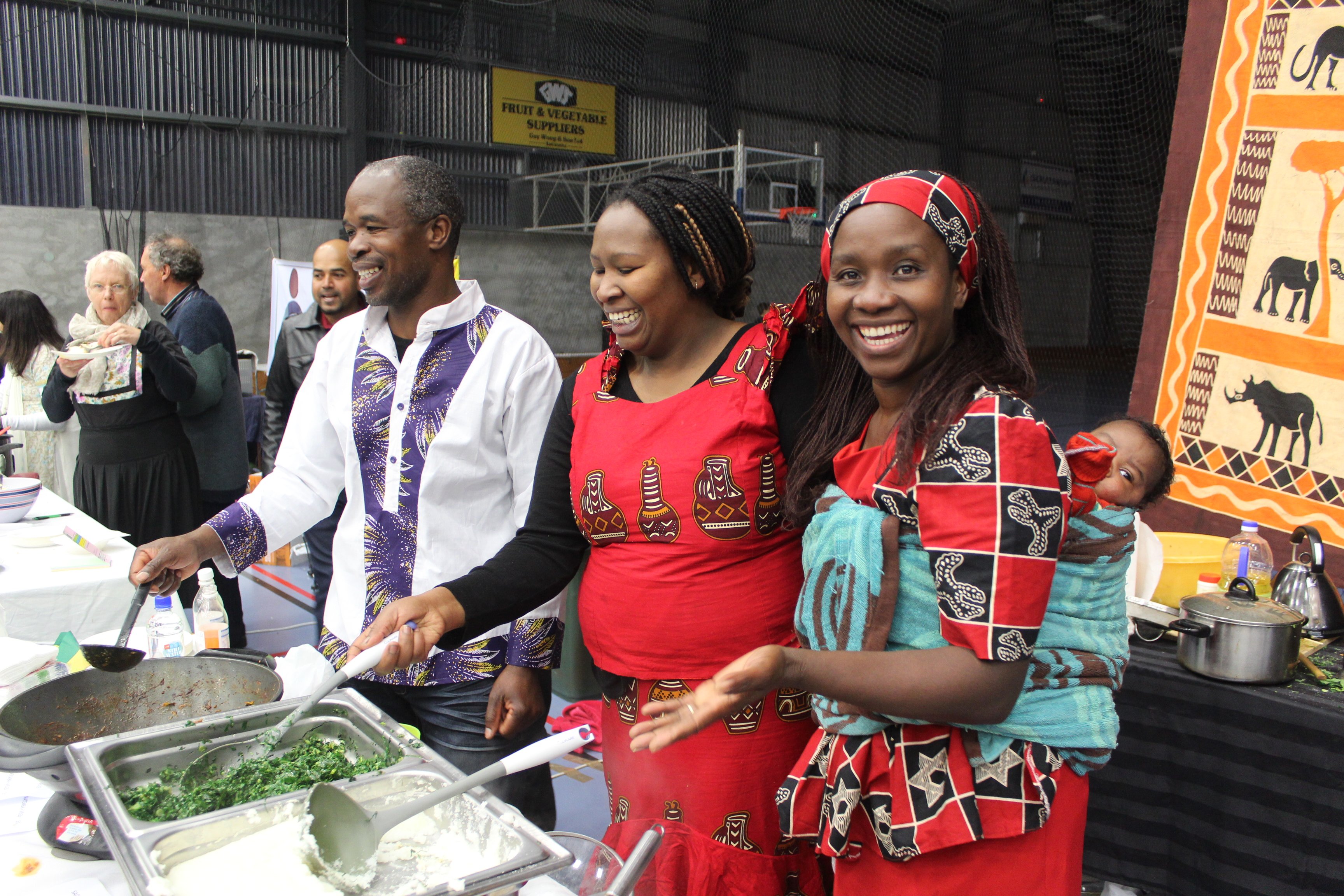 Stall-holders (from left) Marc Makoni, Becky Mbungua and Doreen Makoni with Marcus Mbungua (5 weeks) on her back, serving Zimbabwean food at the Clutha Culture Festival. Photo: Samuel White.