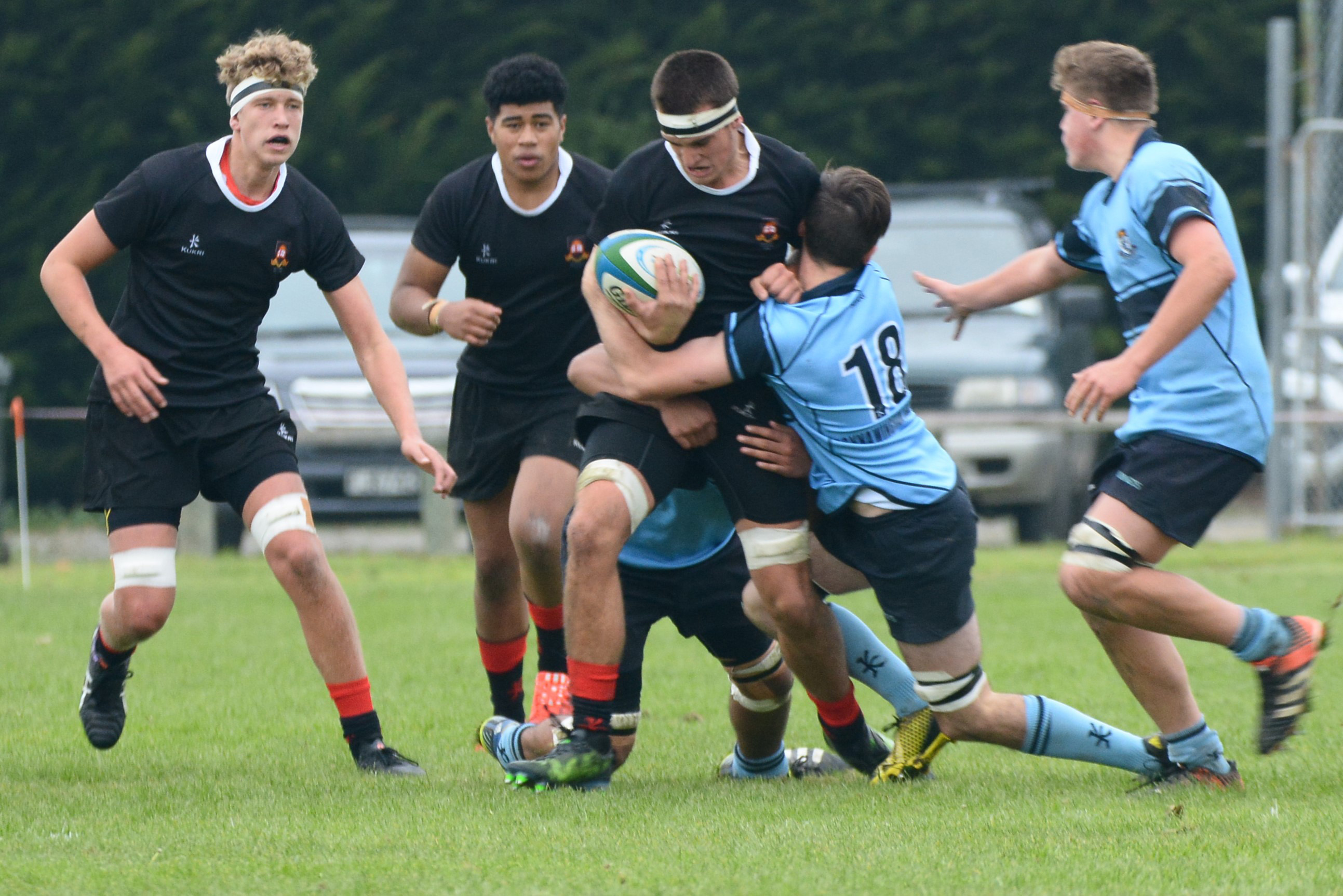 Waitaki Boys' High School player Paddy Henwood tries to bust the tackle of King's High School's...