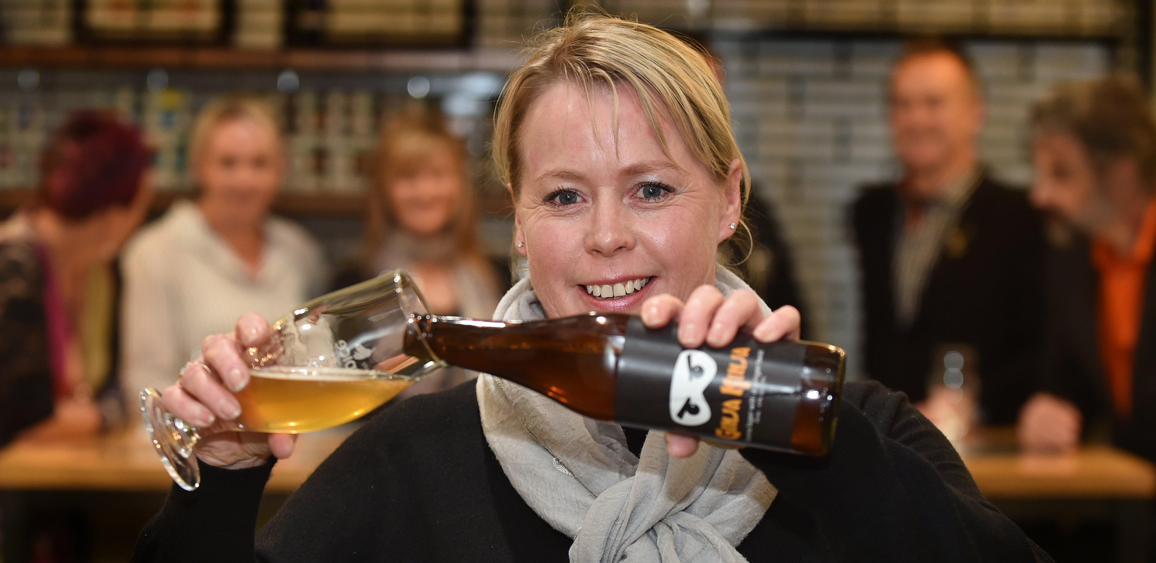 Otago Community Hospice chief executive Ginny Green pours a specially brewed ginger-infused Vienna lager at a hospice fundraising event at Otago Polytechnic on Saturday. Photo: Peter McIntosh.
