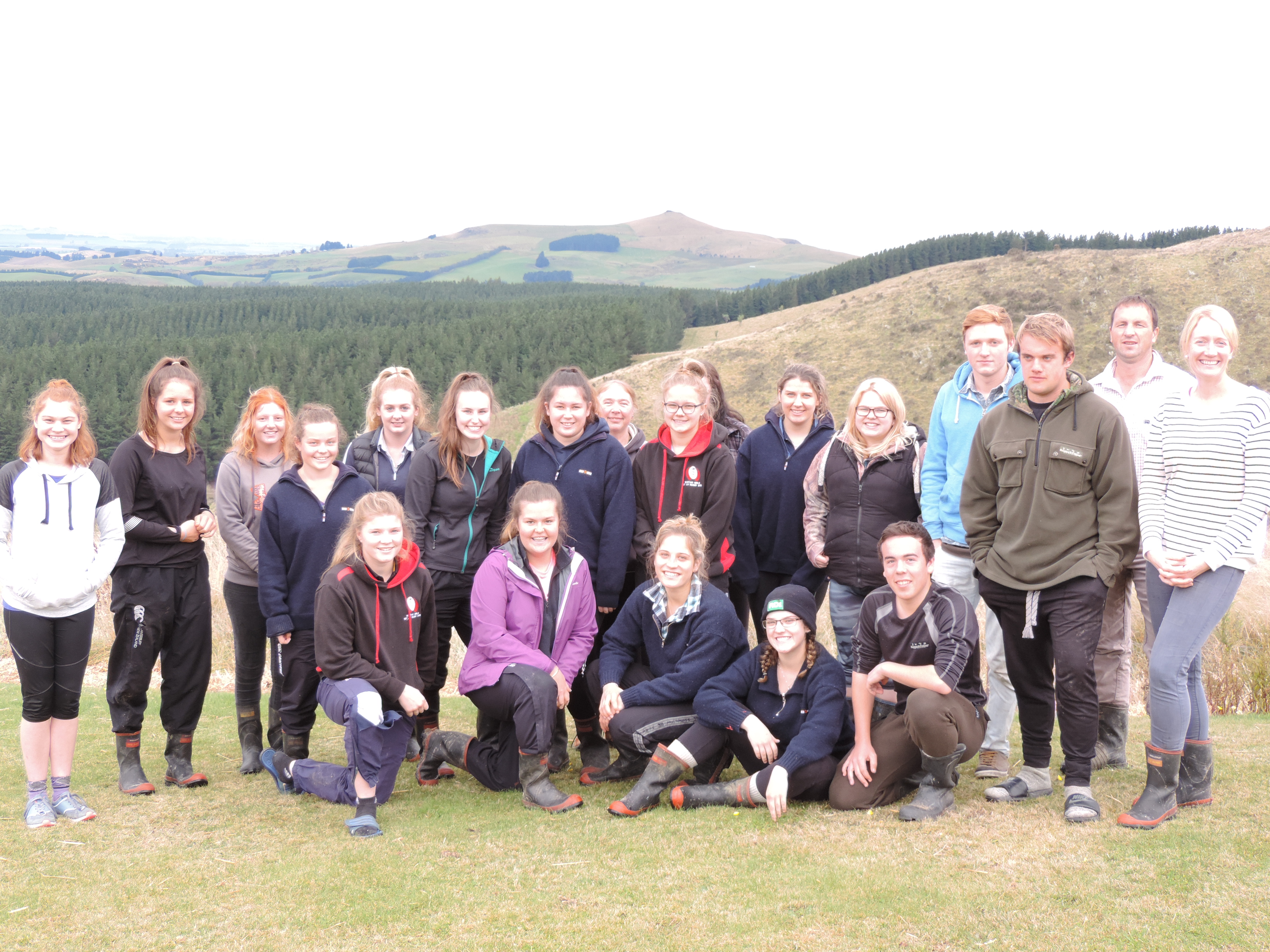 Year 13 pupils from Waitaki Girls' and Waitaki Boys' High Schools, with teacher Jen Howden (rear centre), visited a North Otago hill country property to see how it is farmed by Blair and Jane Smith (right). Photo: Sally Brooker.