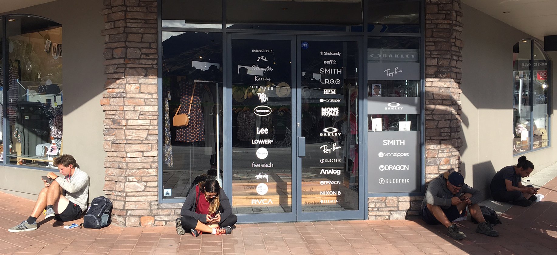 People sit on the footpath outside the Base Streetwear clothing store in Wanaka to use Spark's free Wi-Fi zone, based just outside the shop on the corner of Helwick and Dunmore Sts. Base owner Chris Walsh says the number of people who sit outside the shop