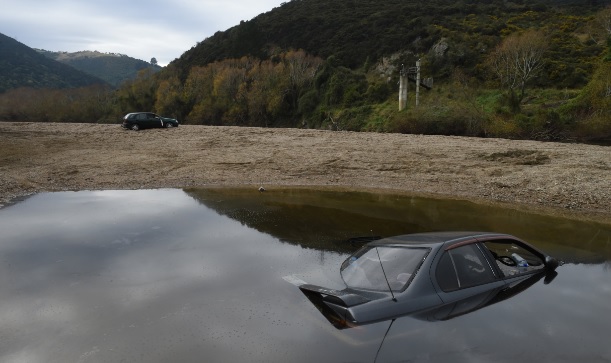 A Nissan Primera was driven into the Taieri River and a Sentra was abandoned on the riverbank at...