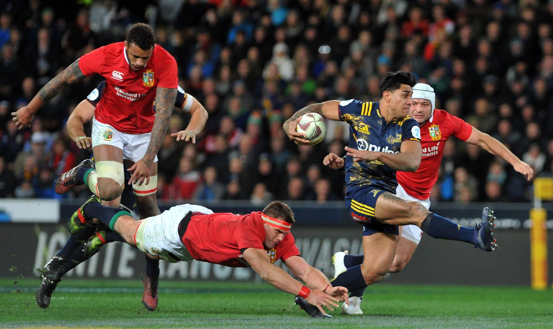 Malakai Fekitoa leaves Lions players (from left) Courtney Lawes, CJ Stander and Rory Best at sixes and sevens at Forsyth Barr Stadium last night. Photo: Gerard O'Brien